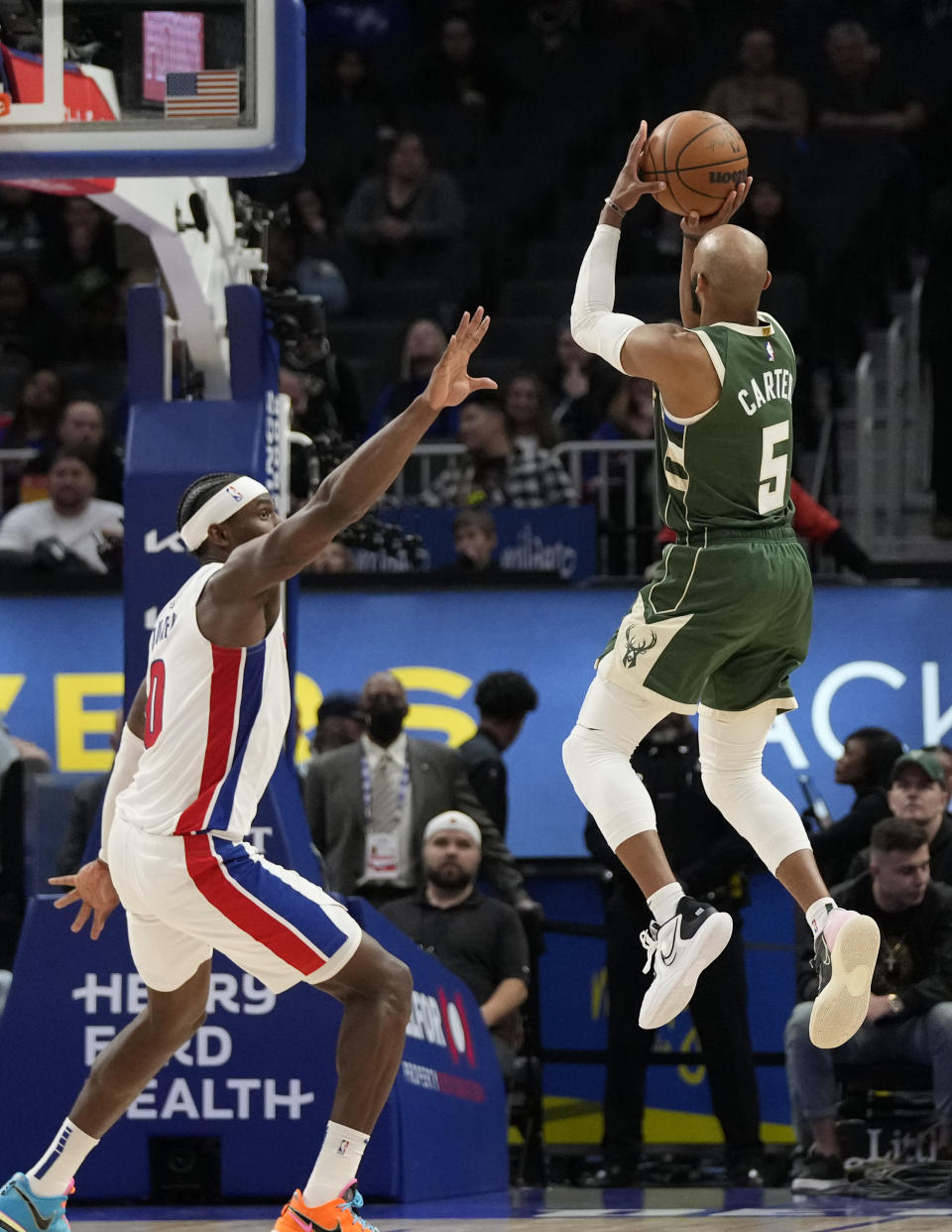 Milwaukee Bucks guard Jevon Carter (5) shoots over the defense of Detroit Pistons center Jalen Duren during the second half of an NBA basketball game, Monday, March 27, 2023, in Detroit. (AP Photo/Carlos Osorio)