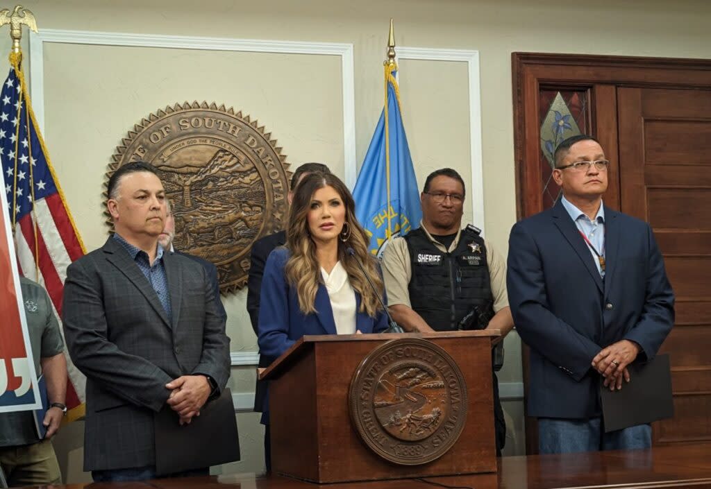 Gov. Kristi Noem, flanked by advisers and law enforcement officials, speaks on May 17, 2024, at the Capitol in Pierre. Visible from left to right around Noem are Tribal Relations Secretary David Flute, Dewey County Sheriff Ashley Arpan and Tribal Law Enforcement Liaison Algin Young. (John Hult/South Dakota Searchlight)