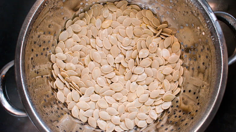 Clean raw pumpkin seeds in colander