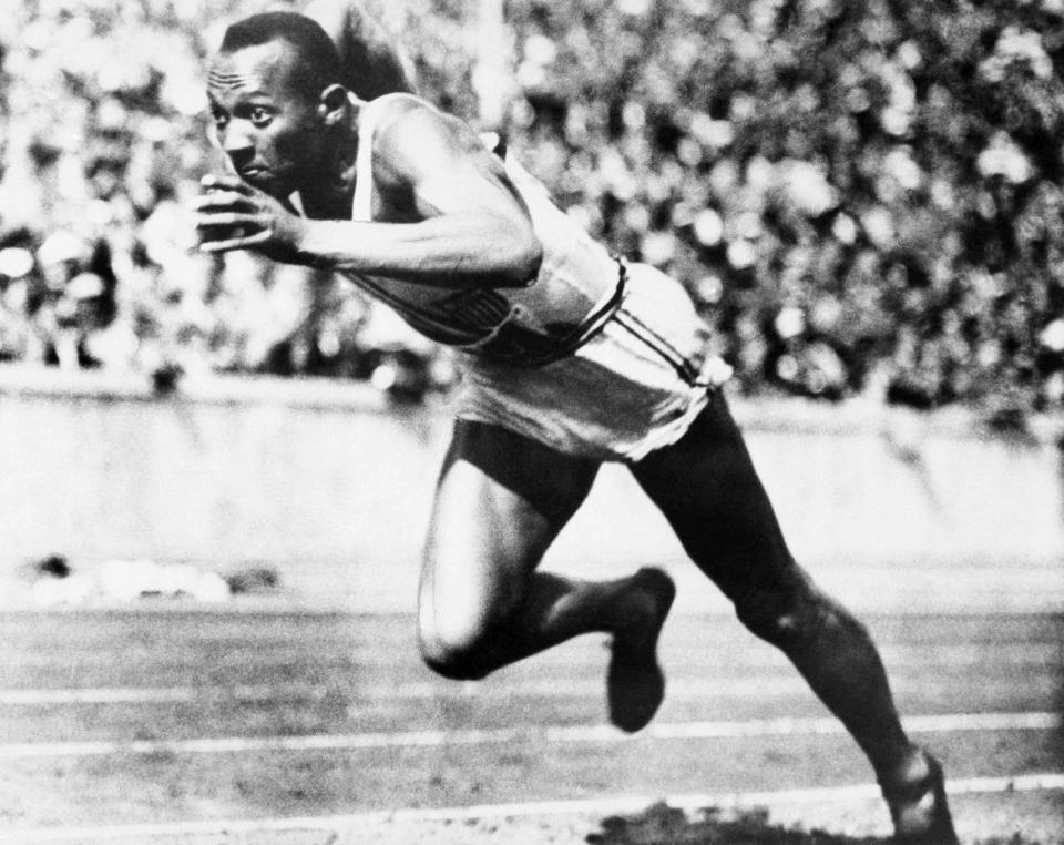 FILE - In this is Aug. 14, 1936 file photo, Jesse Owens competes in one of the heats of the 200-meter run at the 1936 Olympic Games in Berlin. Scars of World War II and relics from its Nazi past are preserved at Berlin's Olympiastadion. When Spain plays England in the European Championship final, they will be playing in a stadium that doesn't hide it was built by the Nazis for the 1936 Olympic Games. (AP Photo, File)