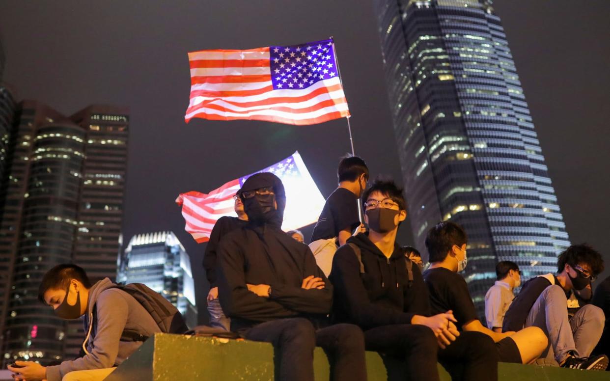 Protesters sit next to a U.S. flag as they attend a gathering at the Edinburgh place in Hong Kong, China, November 2 - REUTERS