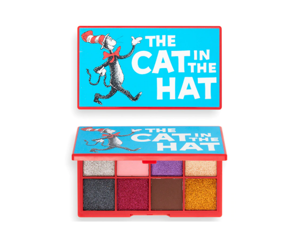 Against a white background, the blue cover of the rectanguar Cat In The Hat eyeshadow palette sits on the top with the cat drawing and the title of the book in bold white writing on the right. Beneath is the same palette with the lid opened showing eight square eye shadows in colourful metallics and two soft matte shades in pink and brown.