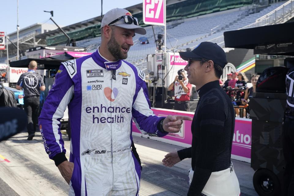 FILE - Shane van Gisbergen, left, and Kamui Kobayashi talk before a practice session for the NASCAR Cup Series auto race at Indianapolis Motor Speedway, Saturday, Aug. 12, 2023, in Indianapolis. Van Gisbergen took NASCAR by storm last season by winning the inaugural Chicago Street Race in his first-ever NASCAR Cup Series race.(AP Photo/Darron Cummings, File)