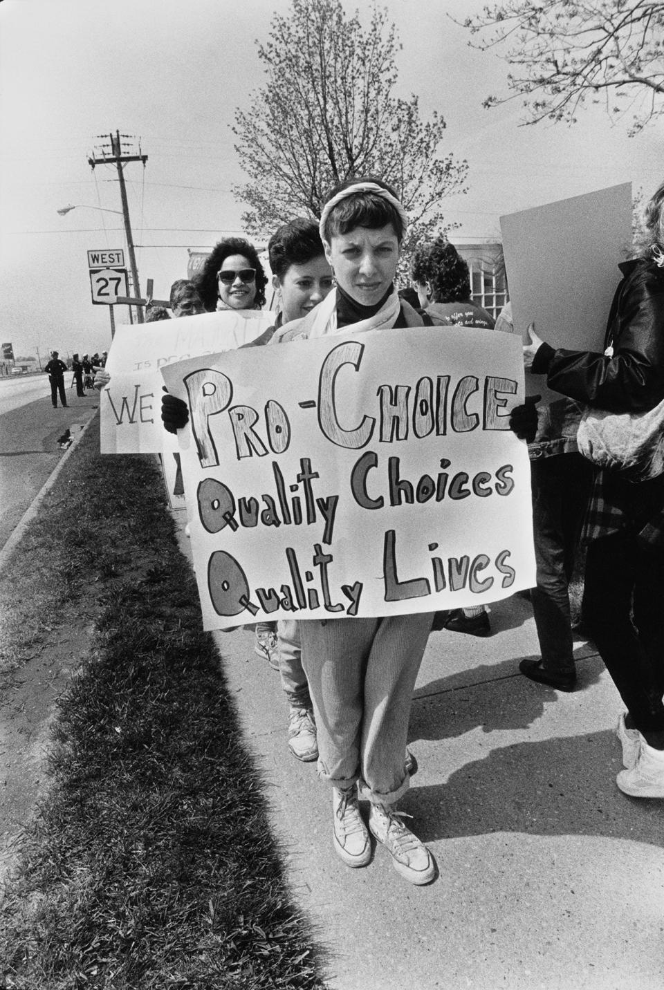 A demonstrator's sign reads "pro-choice, quality choices, quality lives"