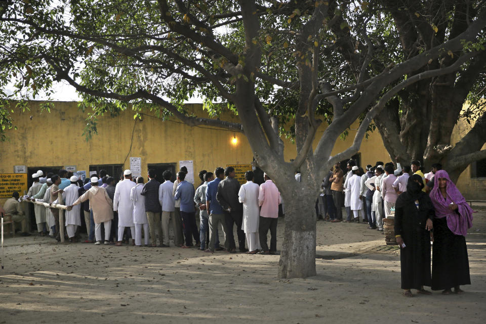 FILE - In this Thursday, April 11, 2019 file photo, Indians stand in a queue to cast their votes outside a polling station in Sawaal village, near Meerut, India. The final phase of India’s marathon general election will be held on Sunday, May 19. The first of the election’s seven staggered phases was held on April 11. Vote counting is scheduled to start on May 23. India has 900 million eligible voters. (AP Photo/Altaf Qadri, File)