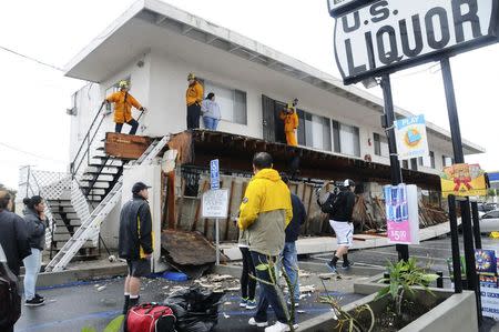 A second-storey walkway to apartment units is shown after it collapsed during heavy rains in Long Beach, California, December 12, 2014. REUTERS/Bob Riha Jr.