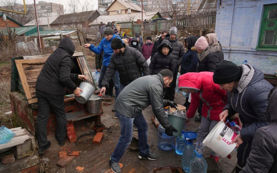 People line up to get water at the well in outskirts of Mariupol, - Evgeniy Maloletka /AP