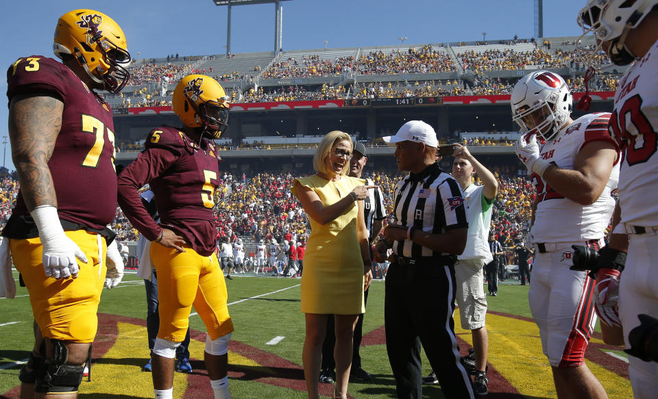 Democratic U.S. Senate candidate Kyrsten Sinema talks with the referee during the coin toss before an NCAA college football game between Arizona State and Utah, Saturday, Nov 3, 2018, in Tempe, Ariz. (AP Photo/Rick Scuteri)