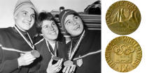 <p>The 1964 medal design for the IX Winter Olympic Games features an Alpine scene. The 1964 Winter Olympics were held in Innsbruck, Austria.<br>(Women’s Giant Slalom winners, (L-R) France’s Christine Goitschell (gold), USA’s Jean Saubert (bronze), France’s Marielle Goitschell (silver)/Getty Images; IOC photo) </p>