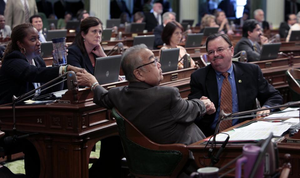 Assemblyman Warren Furutani, D-Lakewood, center, receives congratulations from Assemblywoman Holly Mitchell, D- Hollywood, left, and Assemblyman Rich Gordon, D-Menlo Park after his pension reform bill was approved by the Assembly at the Capitol in Sacramento, Calif., Friday, Aug. 31, 2012. The measure, AB340, a sweeping pension compromise plan negotiated by Gov. Jerry Brown and Democratic legislative leaders, was approved by a 49-8 vote. (AP Photo/Rich Pedroncelli)