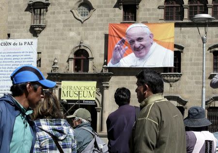 Pedestrians walk at San Francisco square where an image of Pope Francis is displayed in La Paz June 30, 2015. REUTERS/David Mercado