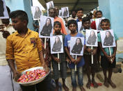 A child holds a tray of chocolates as others hold portraits of U.S. Vice President-elect Kamala Harris after participating in special prayers ahead of her inauguration, at a Hindu temple in Thulasendrapuram, the hometown of Harris' maternal grandfather, south of Chennai, Tamil Nadu state, India, Wednesday, Jan. 20, 2021. A tiny, lush-green Indian village surrounded by rice paddy fields was beaming with joy Wednesday hours before its descendant, Kamala Harris, takes her oath of office and becomes the U.S. vice president. (AP Photo/Aijaz Rahi)