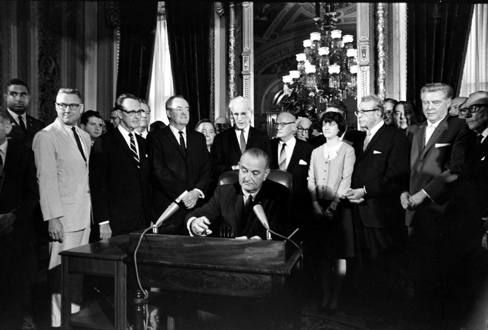 President Lyndon Johnson signs the Voting Rights Act on Aug. 6, 1965. Behind him is daughter Luci Johnson.