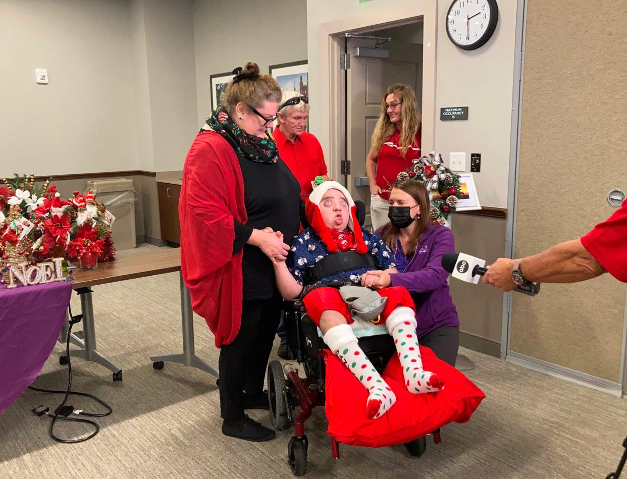 William Thompson is surrounded by family and friends during an interview with media at the Stephen R. Chapman Family Community Campus of Community Hospice & Palliative Care on Dec. 10, 2021. Thompson and his mother, Lisa Feller, left, made Christmas arrangements and wreaths for families served by Community PedsCare.