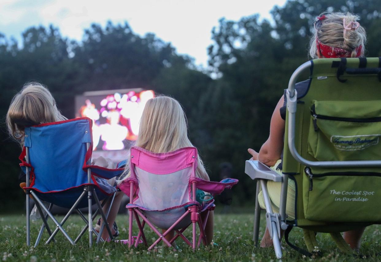 Grove City resident Megan Huffman and her daughters, Quinee, 4, and Cora, 6, watch Disney's "Encanto" at the Naz Church on Aug. 3 The church held Community Outdoor Movie Nights throughout summer, and the Aug. 3 presentation was the season's last event.