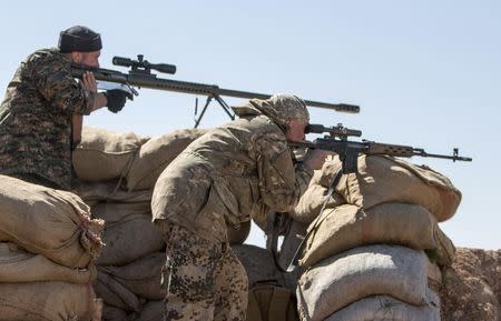 Foreign fighters who joined the Kurdish People's Protection Units (YPG) aim their weapons during what the YPG said was an offensive against them by Islamic State fighters, in the western countryside of Ras al-Ain March 10, 2015. REUTERS/Rodi Said