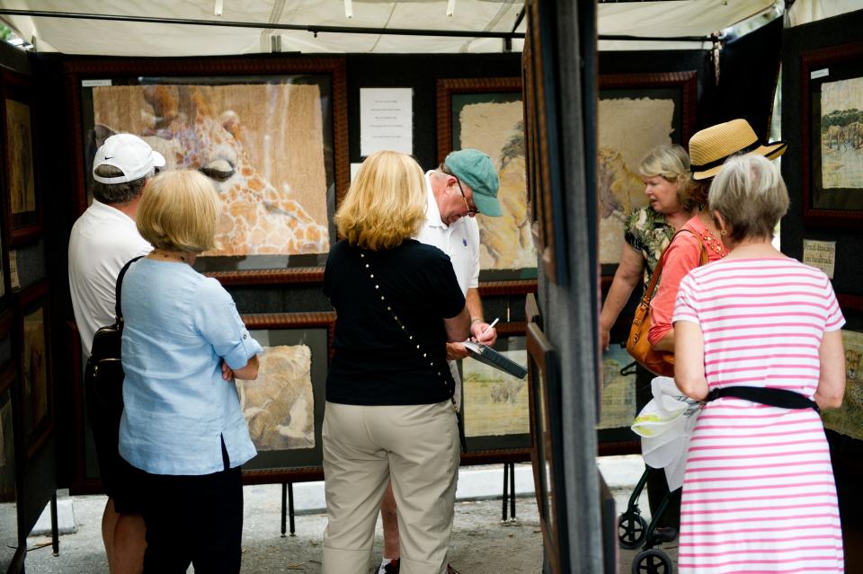 People gather from booth to booth at a Bonita Springs art show in 2015. The Bonita Springs National Art Festival this weekend is 10 a.m.-5 p.m., Saturday, Jan. 13, 2024, and Sunday, Jan. 14, 2024, in Riverside Park.