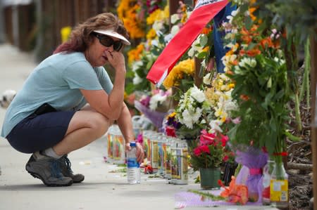 A woman pauses as she looks over a makeshift memorial near Truth Aquatics as the search continues for those missing in a pre-dawn fire that sank a commercial diving boat near Santa Barbara, California