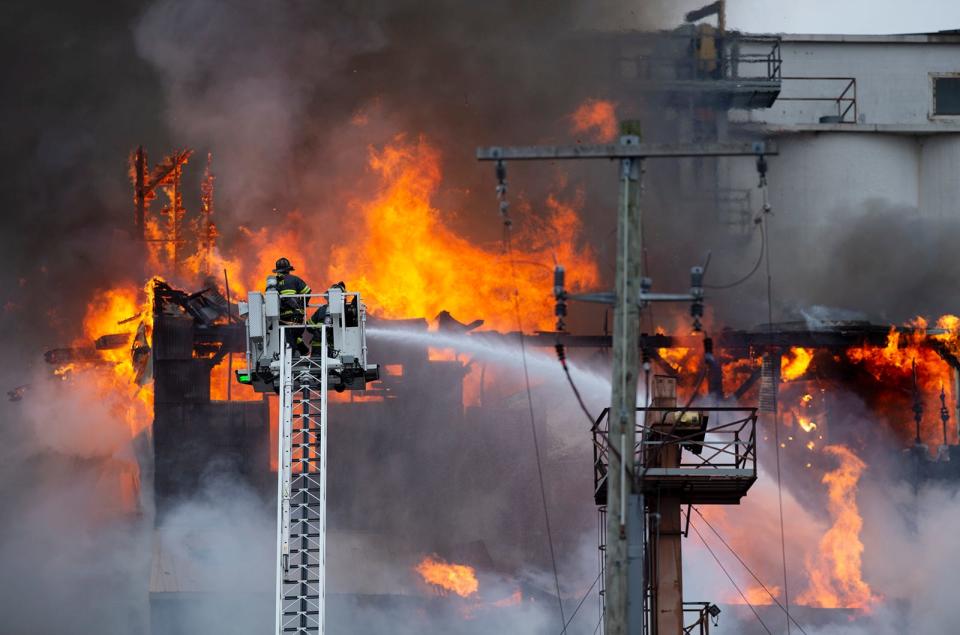 Firefighters from multiple departments battle a large fire Friday morning at a former mill complex on North Water Street in Kent.