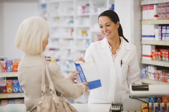 A pharmacist hands out a prescription.