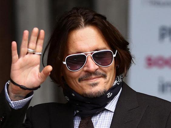 Johnny Depp waves as he arrives at the High Court in London (REUTERS/Hannah McKay)