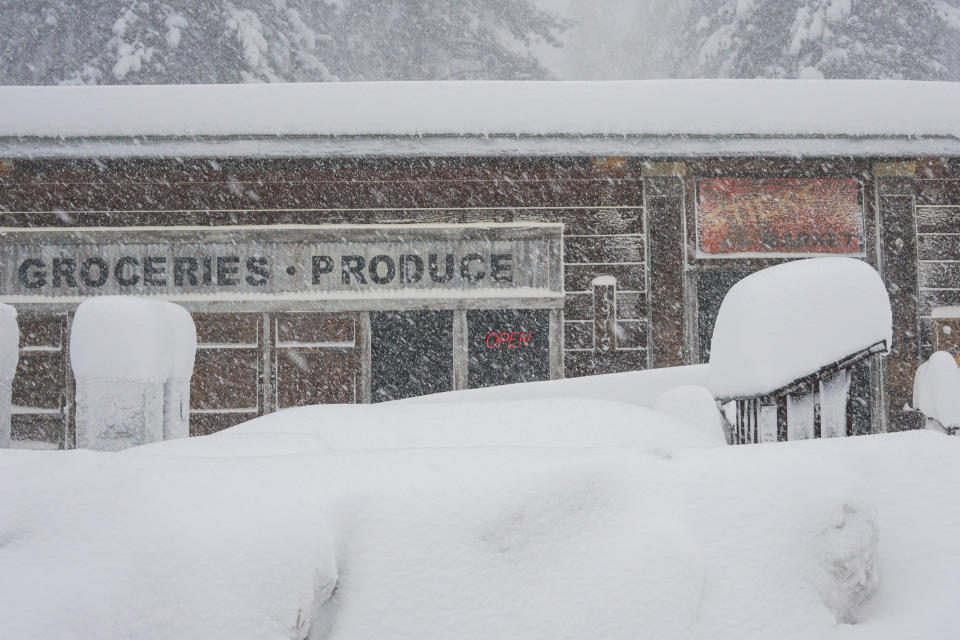 Snow covers the landscape in front of a store, during a storm, Saturday, March 2, 2024, in Truckee, Calif. A powerful blizzard howled Saturday in the Sierra Nevada as the biggest storm of the season shut down a long stretch of Interstate 80 in California and gusty winds and heavy rain hit lower elevations, leaving tens of thousands of homes without power. (AP Photo/Brooke Hess-Homeier)