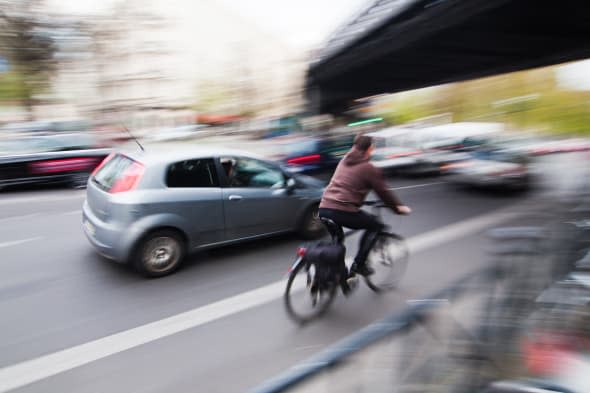 city traffic with a cyclist and cars in motion blur