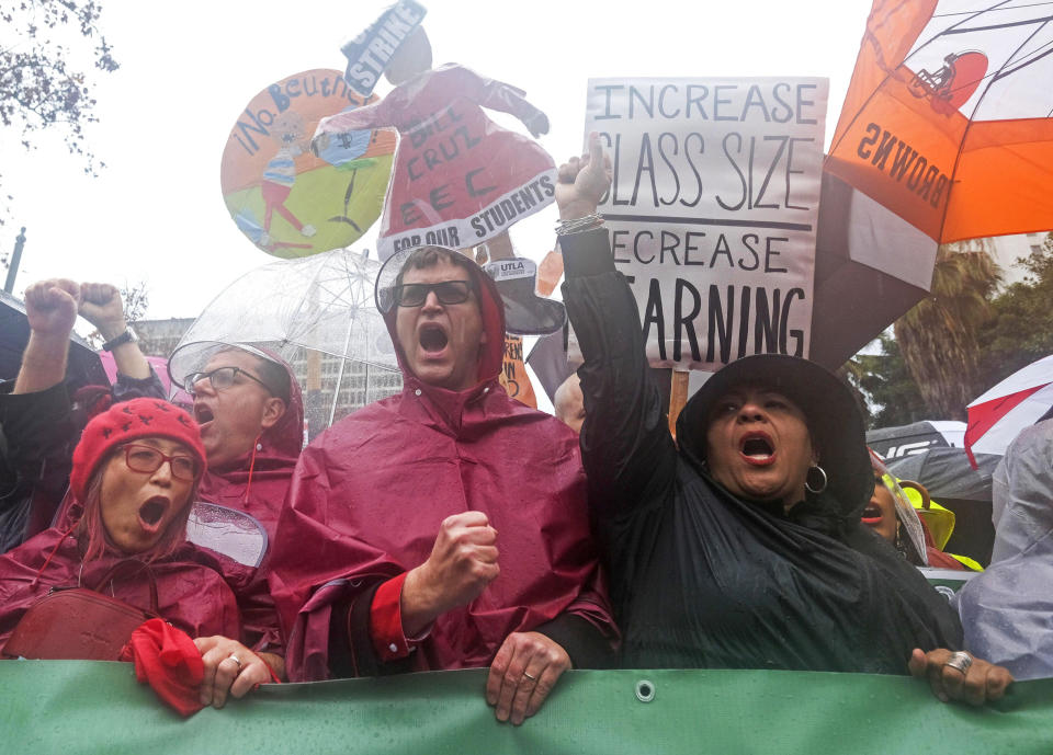 FILE - In this Monday, Jan. 14, 2019 file photo, teachers and supporters rally in the rain in Los Angeles. Los Angeles teachers who declared a victory after a six-day strike have added momentum to a wave of activism by educators. They've tapped a common theme and found success by framing their cause as a push to improve public education, not just get pay raises. (AP Photo/Ringo H.W. Chiu, File)