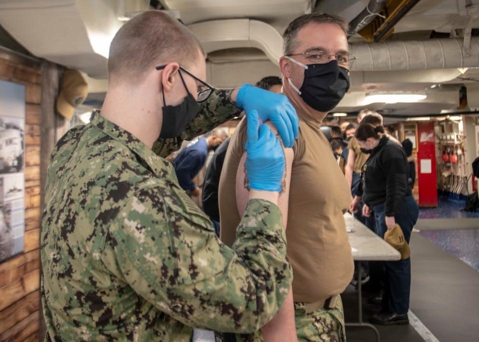 USS Nimitz Command Master Chief David Conduff receives the Moderna COVID-19 vaccine in 2021 aboard the Nimitz after it returned to port in Bremerton following a record-long deployment.