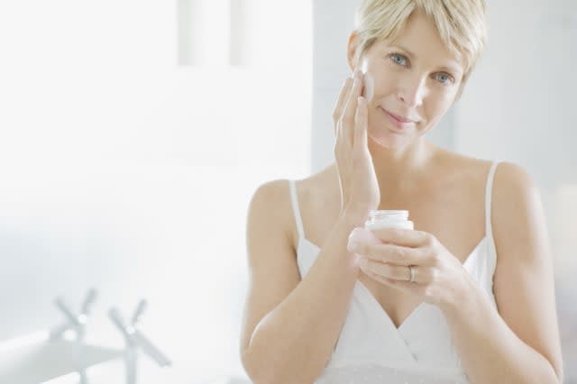 Woman applying face cream in the morning
