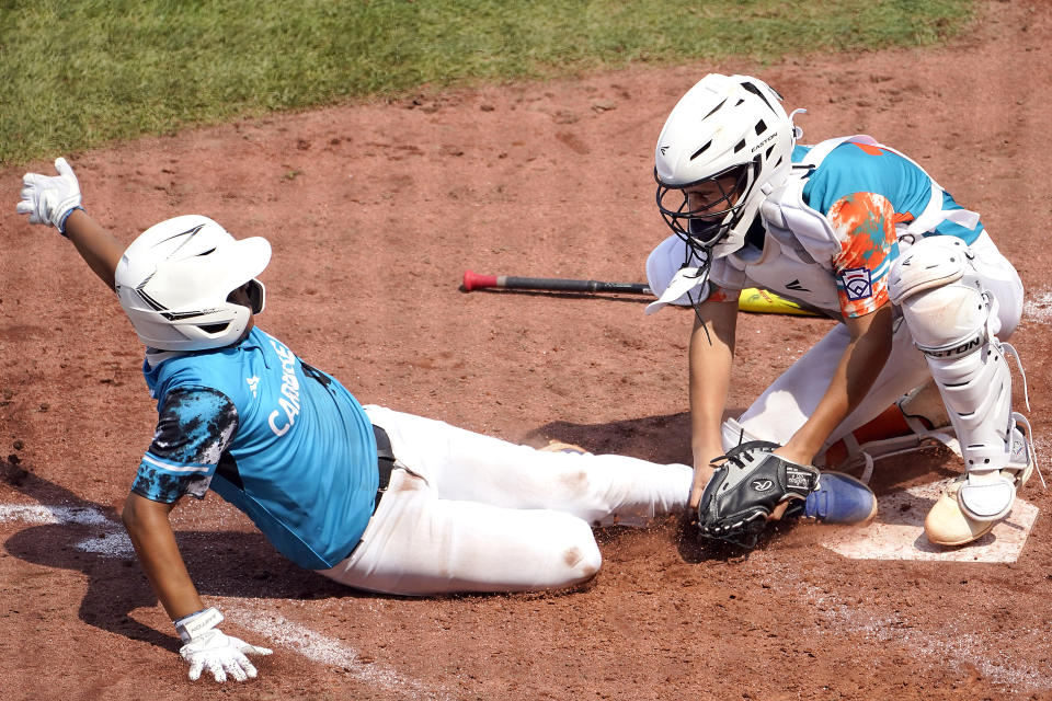 Venezuela catcher Adrian Soto tags out Curacao's Jay-Dlynn Wiel (10) at home plate as he attempted to score on a ball hit by Joshua Acosta Fernandez to end the third inning of a baseball game at the Little League World Series tournament in South Williamsport, Pa., Monday, Aug. 21, 2023. (AP Photo/Tom E. Puskar)