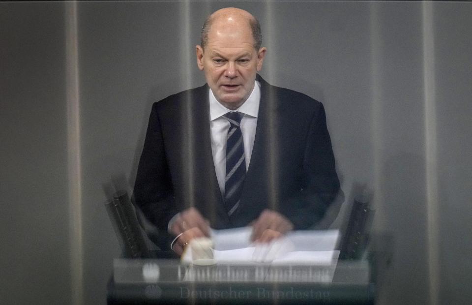 German Chancellor Olaf Scholz delivers a speech during a meeting of the German federal parliament, Bundestag, at the Reichstag building in Berlin, Germany, Wednesday, Dec. 15, 2021. The reflections are caused by a metallic handrail at the press tribune. (AP Photo/Michael Sohn)