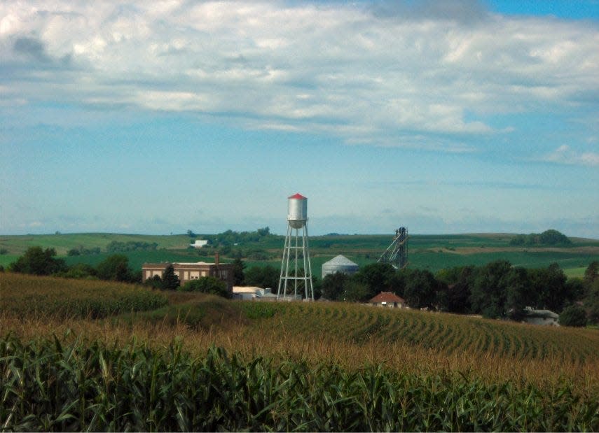 A water tower above a field of corn in Iowa.