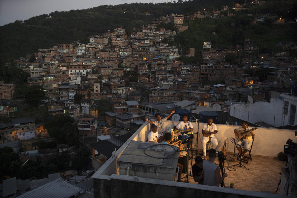 Members of the "Tempero de Criola" band perform amid the new coronavirus pandemic at the Turano favela, in Rio de Janeiro, Brazil, Friday, June 19, 2020. A group of musicians playing Samba offered a small concert to the residents of Turano favela, most of whom remain quarantined to curb the spread of COVID-19. Residents could watch the performance from their windows, balconies or via internet. (AP Photo/Silvia Izquierdo)