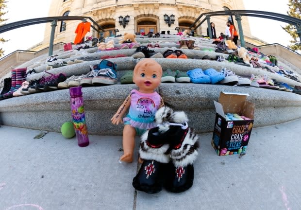 Hundreds of shoes and stuffed animals were left on the steps of the Saskatchewan legislature this weekend in honour of 215 children whose bodies were found in a mass grave in Kamploops B.C. earlier this week, on May 30, 2021 in Regina. (Bryan Eneas/CBC News  - image credit)