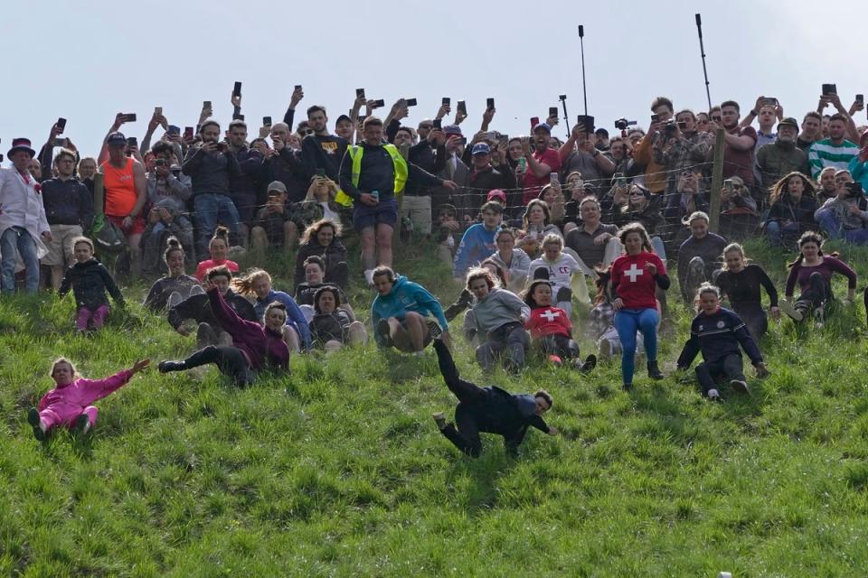 Participants compete in the women's downhill race during the cheese rolling contest at Cooper's Hill in Brockworth (AP)