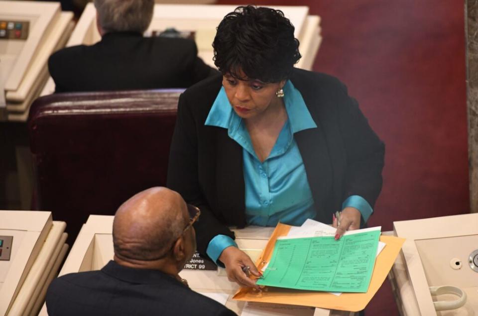 A woman presenting a folder to a man