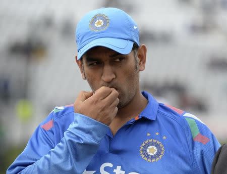 India's Mahendra Singh Dhoni looks on before the coin toss before the third one-day international cricket match against England at Trent Bridge cricket ground, Nottingham, England August 30, 2014. REUTERS/Philip Brown/Files