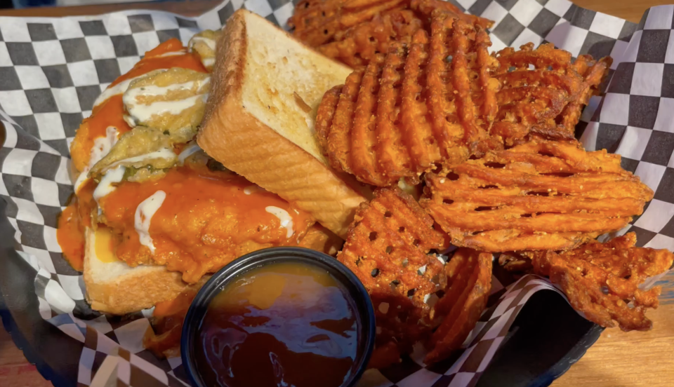 The fried pickle Buffalo chicken sandwich at Blue Moose Burgers & Wings in Alcoa is a fried chicken breast drizzled with mild sauce and served, along with fried pickles and two slices of American cheese, between slices of Texas toast.