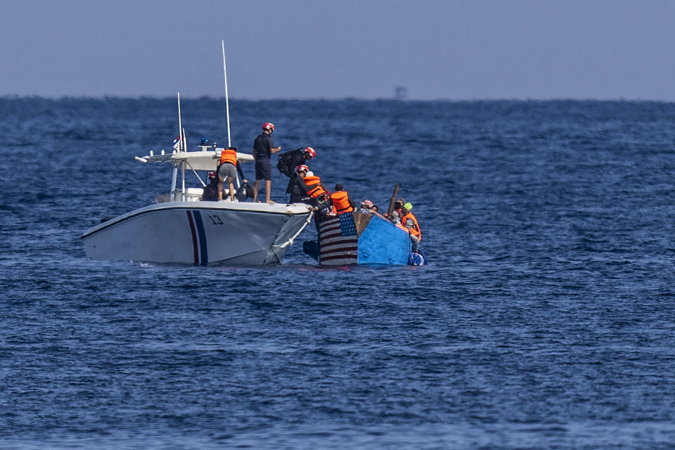 People in a makeshift boat with the U.S. flag painted on the side are captured by the Cuban Coast Guard near the Malecon seawall in Havana, Cuba, Monday, Dec. 12, 2022. (AP Photo/Ramon Espinosa)