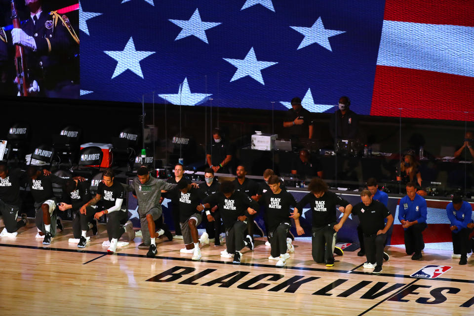 Sep 8, 2020; Lake Buena Vista, Florida, USA; Members of the Milwaukee Bucks including forward Giannis Antetokounmpo (grey sweats) kneel during the playing of the national anthem before game five in the second round of the 2020 NBA Playoffs against the Miami Heat at ESPN Wide World of Sports Complex. Mandatory Credit: Kim Klement-USA TODAY Sports