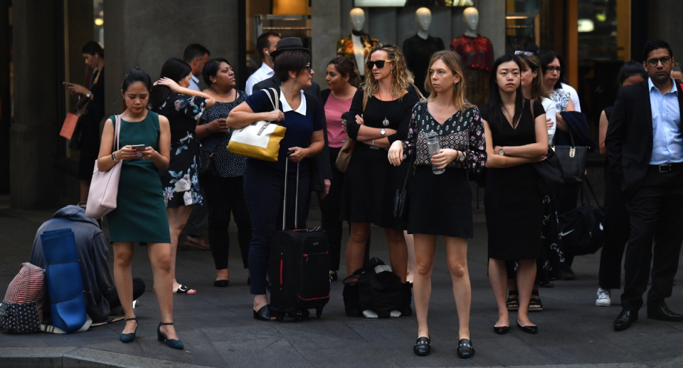 Australian office workers waiting at a crossing. 