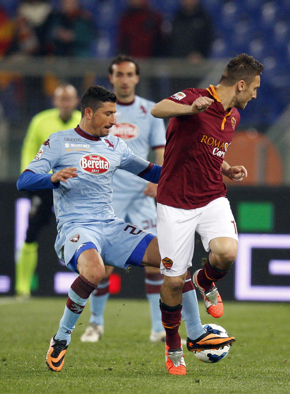 Torino midfielder Giuseppe Vives, left, and AS Roma forward Francesco Totti fight for the ball during a Serie A soccer match between AS Roma and Torino, at Rome's Olympic Stadium, Tuesday, March 25, 2014. (AP Photo/Andrew Medichini)