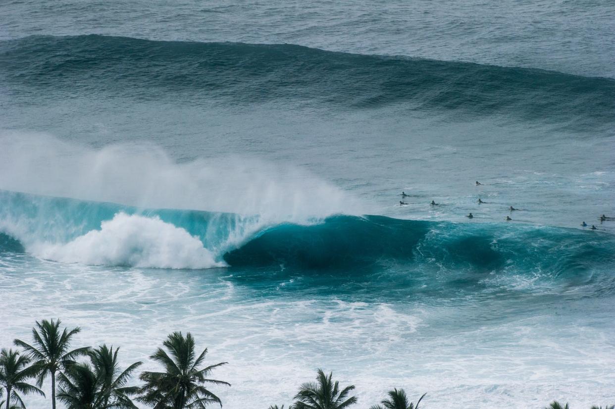 elevated view of surfers and banzai pipeline surfing wave