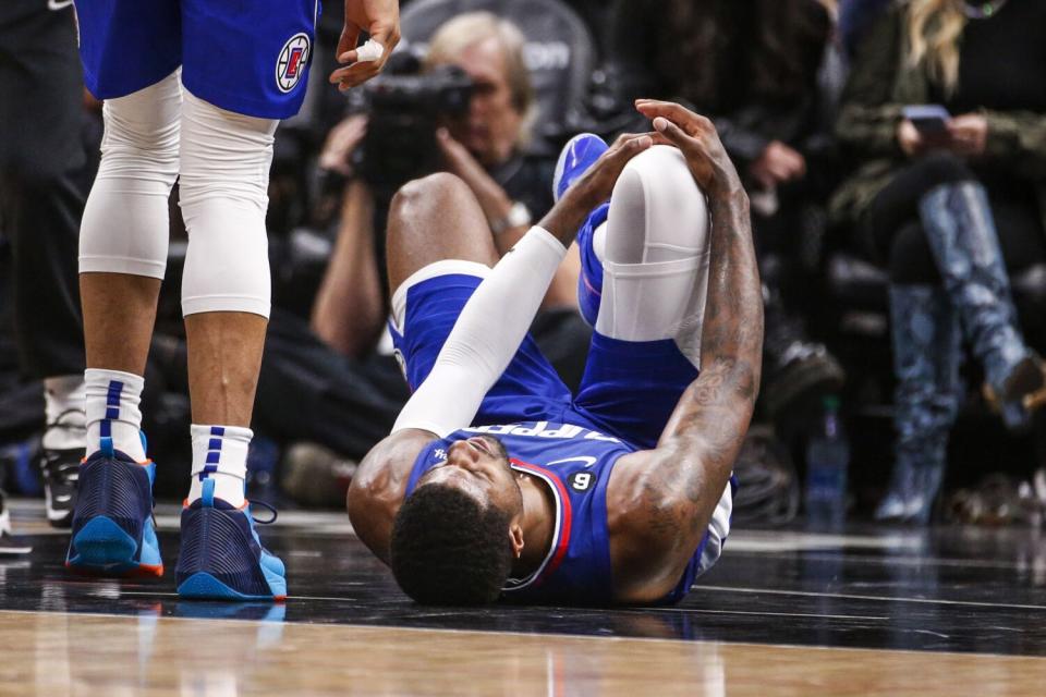 Clippers forward Paul George grabs his knee after suffering an injury against Oklahoma City on Tuesday.