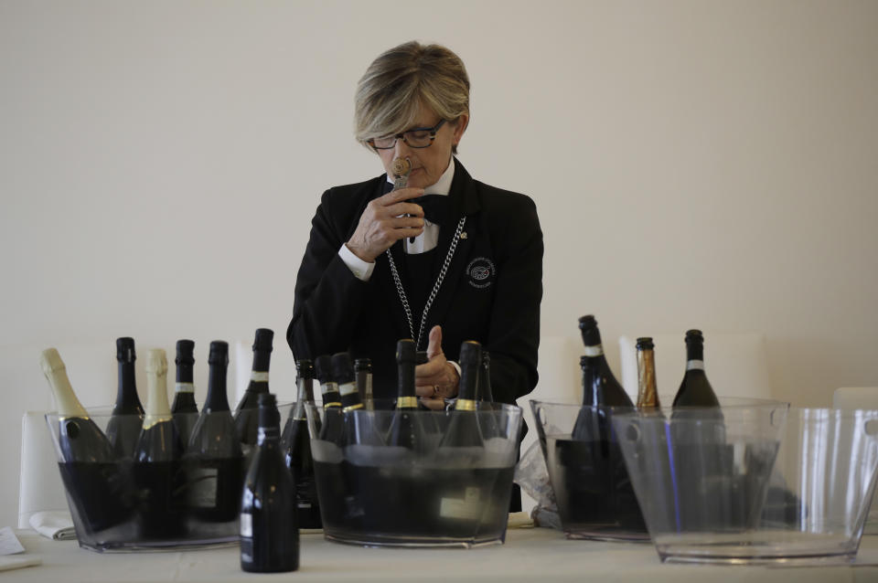 In this image taken on Monday, Oct. 15, 2018, a sommelier opens Prosecco bottles during a wine testing in Asolo, Italy. Global sales of prosecco the smooth, drinkable sparkling wine rooted in the northeastern hills of Italy are booming, and champagne, the original bubbly, is taking note. (AP Photo/Luca Bruno)