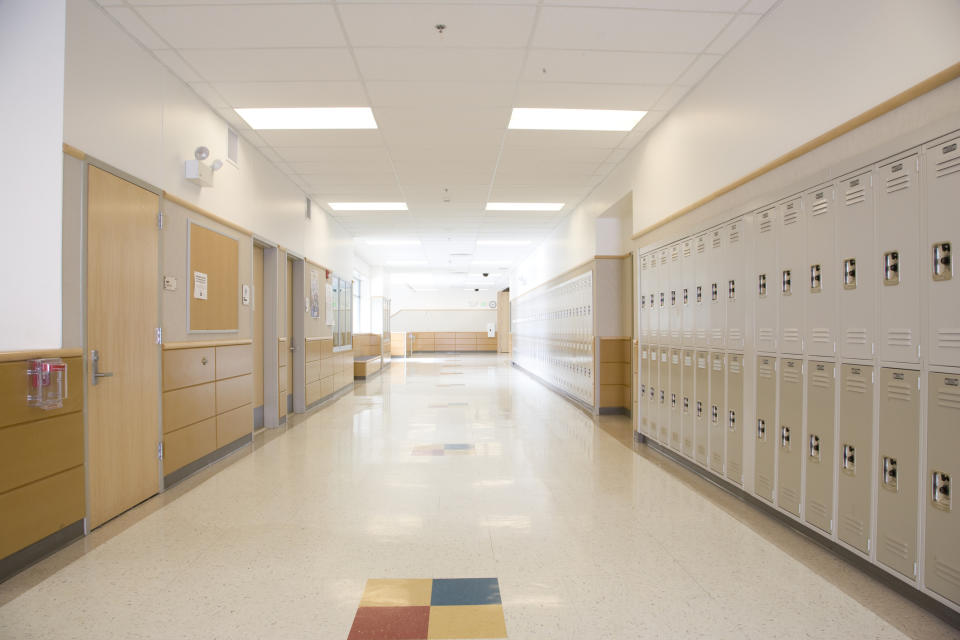 Empty school hallway with lockers and classrooms on both sides