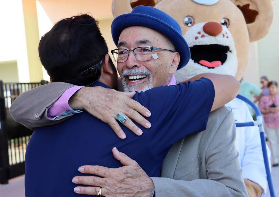 Former U.S. Poet Laureate Juan Felipe Herrera hugs a family m ember during the opening ceremony for the elementary school named after him on Aug. 22, 2022