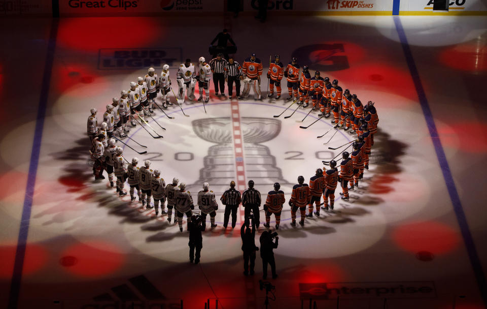 The Edmonton Oilers and the Chicago Blackhawks circle for the national anthem before an NHL hockey Stanley Cup playoff game in Edmonton, Alberta, Saturday, Aug. 1, 2020. (Jason Franson/The Canadian Press via AP)