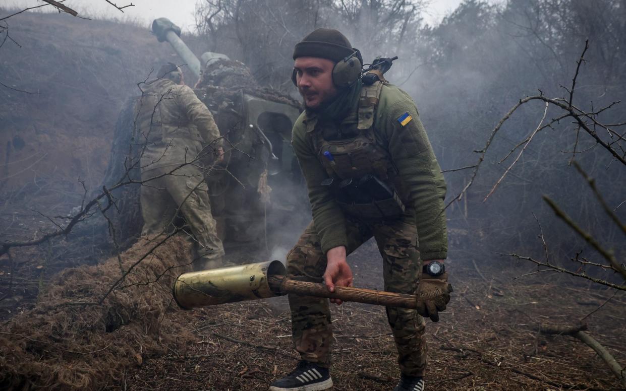 Ukrainian servicemen of the 126th Separate Territorial Defence Brigade load a D-30 howitzer